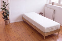 Earthle aardingshoeslaken op een eenpersoonsbed op een houten vloer, 200 x 90 x 30 cm